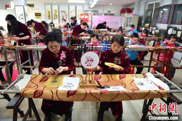 江西省級(jí)非遺豫章繡傳承人手把手指導(dǎo)小學(xué)生繡制2022年北京冬奧會(huì)吉祥物“冰墩墩”形象?！∮髟屏?攝