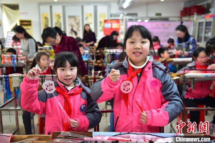 圖為小學(xué)生展示繡制好的2022年北京冬奧會(huì)吉祥物“冰墩墩”形象?！∮髟屏?攝