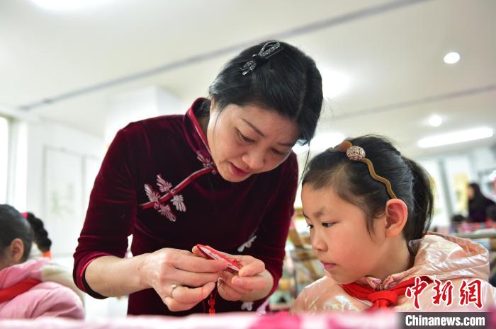 江西省級(jí)非遺豫章繡傳承人手把手指導(dǎo)小學(xué)生繡制2022年北京冬奧會(huì)吉祥物“冰墩墩”形象?！∮髟屏?攝