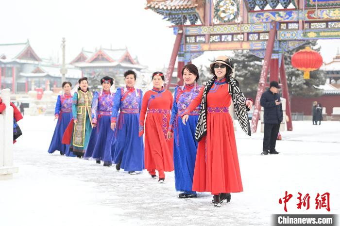 2月13日，老年人在呼和浩特市大召?gòu)V場(chǎng)拍照“打卡”。　劉文華 攝