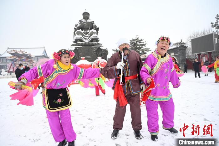 2月13日，秧歌隊(duì)在呼和浩特市大召?gòu)V場(chǎng)雪中起舞?！⑽娜A 攝