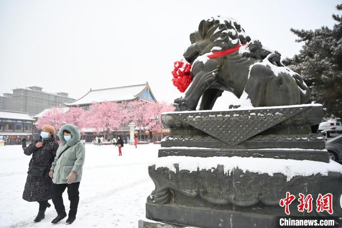 2月13日，民眾在呼和浩特市大召?gòu)V場(chǎng)雪中漫步?！⑽娜A 攝
