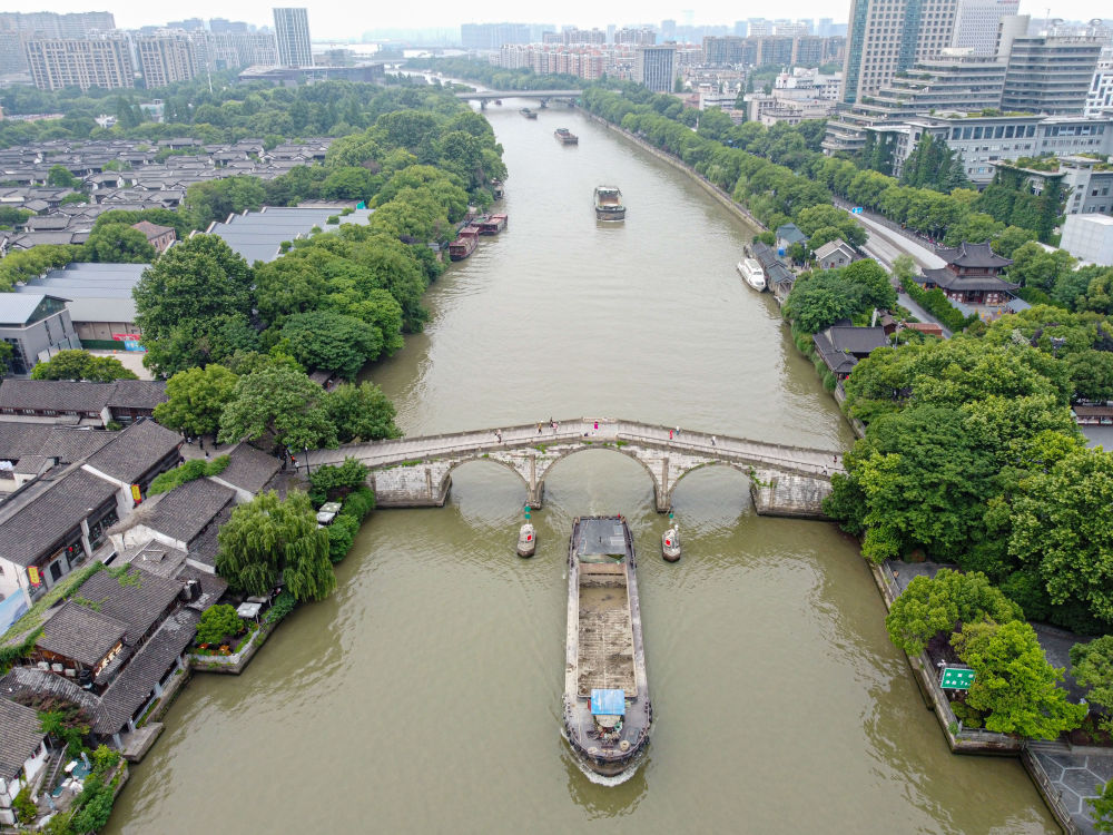 5月27日，一艘貨船駛過京杭大運(yùn)河南端標(biāo)志建筑杭州拱宸橋。(無人機(jī)照片)新華社記者江漢 攝
