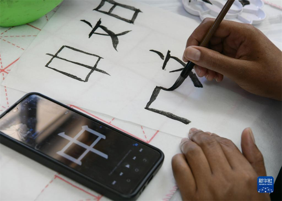 4月18日，肯尼亞學(xué)生在內(nèi)羅畢大學(xué)孔子學(xué)院舉辦的活動(dòng)上寫毛筆字。肯尼亞內(nèi)羅畢大學(xué)孔子學(xué)院18日舉辦“中文，增進(jìn)文明對(duì)話”主題活動(dòng)，慶祝即將到來(lái)的第14個(gè)聯(lián)合國(guó)中文日?？夏醽唽W(xué)生參與互動(dòng)，進(jìn)行書法、剪紙、唱中文歌等活動(dòng)。新華社記者 韓旭 攝