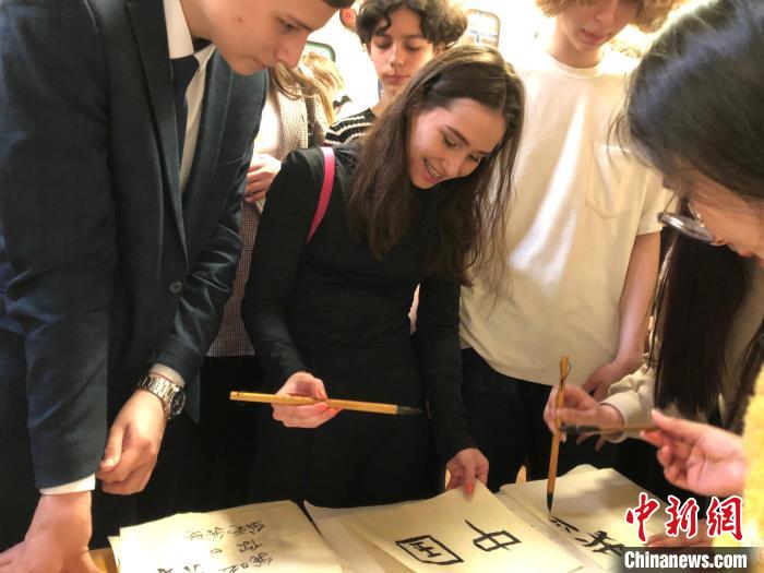 4月21日，莫斯科國立語言大學(xué)孔子學(xué)院附屬中學(xué)舉辦“國際中文日”活動，學(xué)生們學(xué)寫漢字?！∧箍茋⒄Z言大學(xué)孔子學(xué)院 供圖