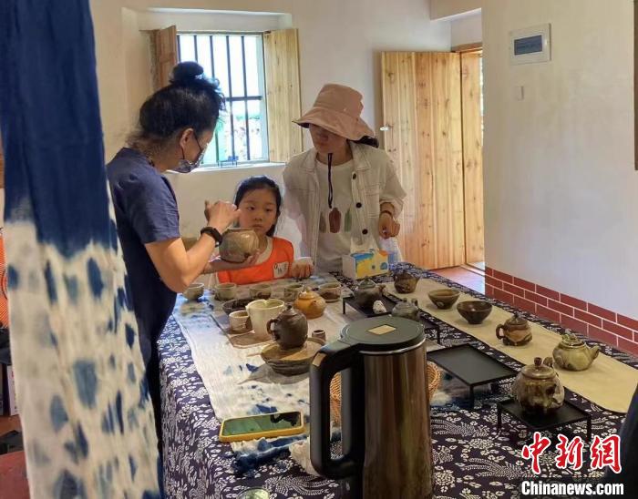 圖為：游客正在咨詢臺(tái)灣柴燒作品?！∪~秋云 攝