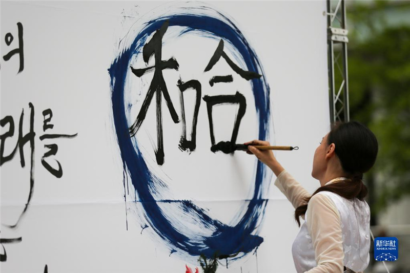 5月30日，在韓國(guó)首爾舉辦的“中日韓合作之日”慶?；顒?dòng)中，表演者進(jìn)行中日韓精神——2023年度漢字“和合”書(shū)法表演。新華社記者 王益亮 攝