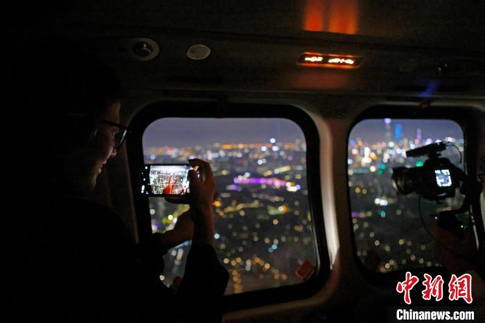 6月3日晚，游客乘坐上海新空直升機(jī)有限公司直升機(jī)開(kāi)啟鳥(niǎo)瞰黃浦江空中圓夢(mèng)之旅，并用手機(jī)拍攝城市夜景。　殷立勤 攝