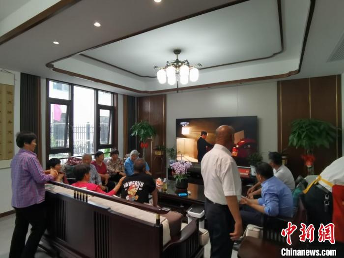 親友們集中在費(fèi)俊龍家中觀看返程的視頻。　鐘升 攝