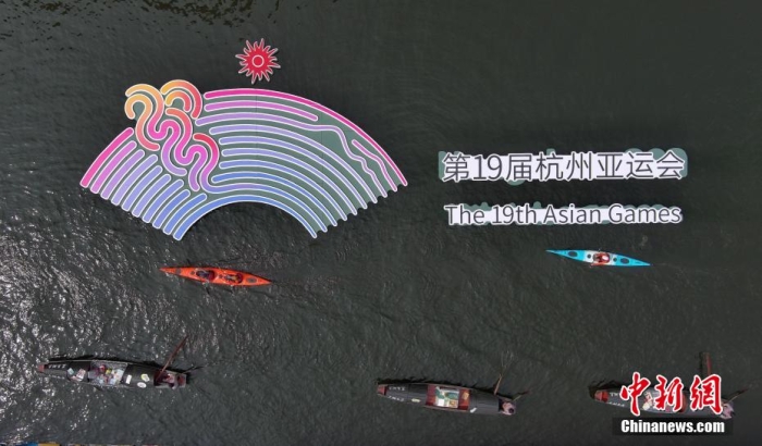資料圖為烏篷船和皮劃艇從杭州亞運會標識前劃過。王剛 攝
