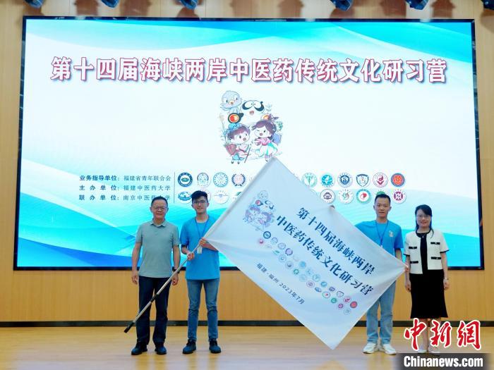 共青團(tuán)福建省委副書(shū)記吳雪(右一)、福建中醫(yī)藥大學(xué)黨委副書(shū)記林羽(左一)為兩岸學(xué)生代表頒授營(yíng)旗?！≡S燁婷 攝