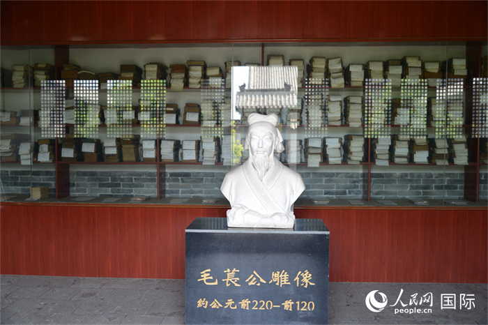 河間詩(shī)經(jīng)齋毛萇雕像。雕像后書(shū)櫥中陳列的是歷代各版本《詩(shī)經(jīng)》及譯本。 人民網(wǎng) 趙昭攝
