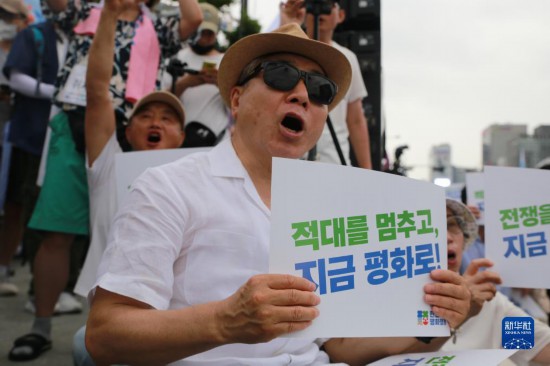 7月22日，在韓國(guó)首爾，人們手舉標(biāo)語參與反戰(zhàn)游行。新華社發(fā)（楊暢 攝）
