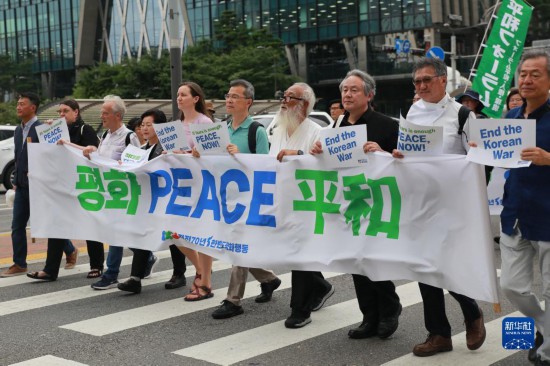 7月22日，在韓國(guó)首爾，人們手舉標(biāo)語參與反戰(zhàn)游行。新華社發(fā)（楊暢 攝）