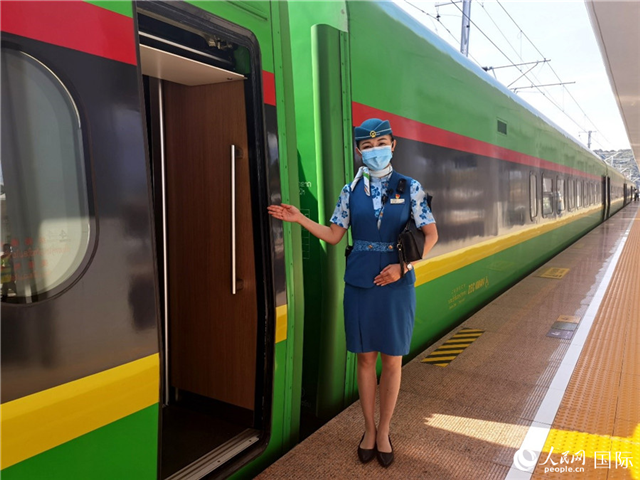 趙瑩靜站在“復(fù)興號(hào)”國(guó)際旅客列車車廂門口歡迎旅客上車。人民網(wǎng) 杜明明攝