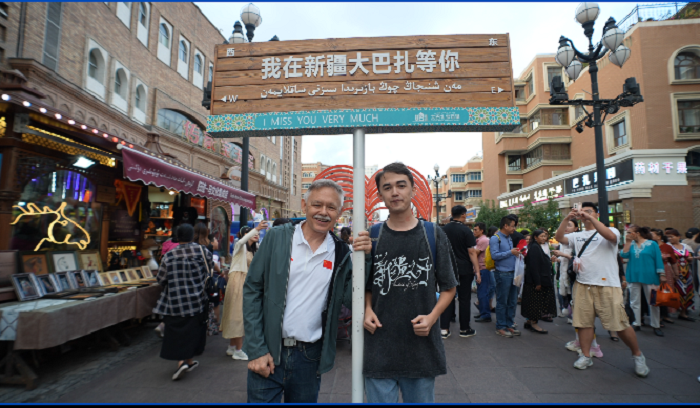 潘維廉和維吾爾族青年伊木蘭“打卡”大巴扎。主辦方供圖