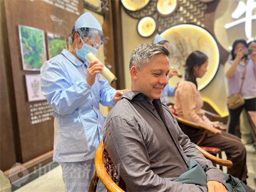   （外媒記者體驗艾灸。中國經(jīng)濟周刊記者 郭志強 攝）