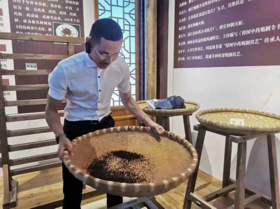 2023“一帶一路”媒體合作論壇聯(lián)合采訪團(tuán)團(tuán)員在非遺文化展示館體驗(yàn)中藥炮制技藝。（本報(bào)記者 黃超攝）