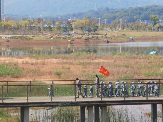 　　10月24日，秋游的幼兒園小朋友在老師帶領(lǐng)下走在清水塘公園里的木橋上。本報(bào)記者 常雯宜攝