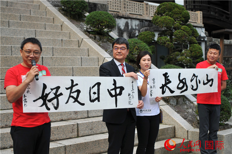 東京中國文化中心主任羅玉泉展示其為本次活動書寫的題詞“中日友好，山高水長”。人民網(wǎng) 蔣曉辰攝