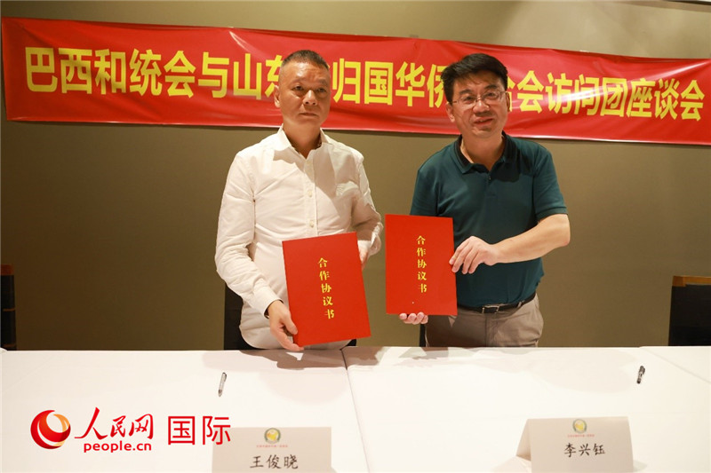 中國(guó)僑聯(lián)副主席、山東省僑聯(lián)主席李興鈺（右）與巴西和統(tǒng)會(huì)會(huì)長(zhǎng)王俊曉簽署合作協(xié)議書(shū)。人民網(wǎng)記者 陳海琪攝