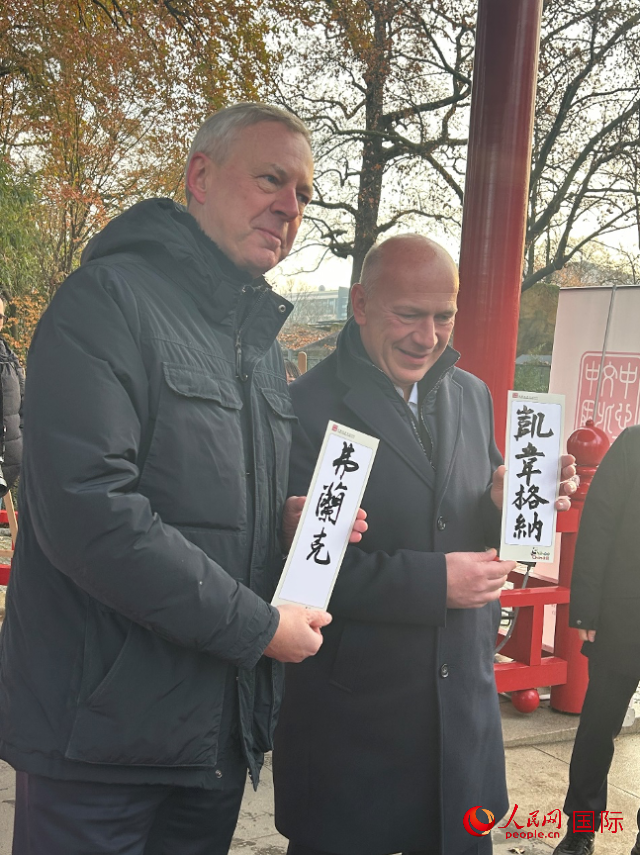 柏林市長韋格納（右）、動物園監(jiān)事會主席布魯克曼（左）手持中國文化中心工作人員現(xiàn)場手書的中文名字。人民網(wǎng)記者 徐馨攝
