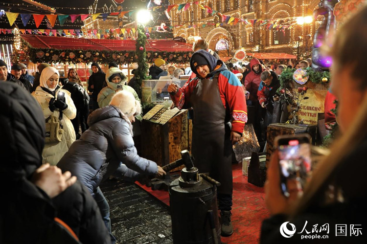 游客在新年集市上體驗制作紀念幣。人民網(wǎng)記者 隋鑫攝
