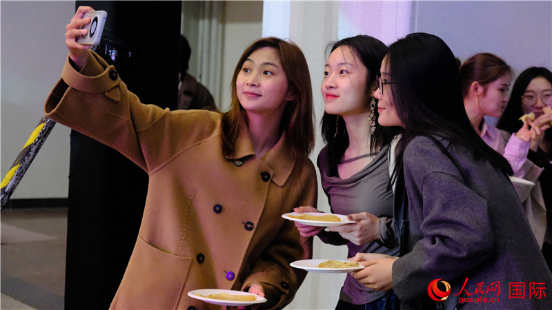 中國觀眾在現(xiàn)場品嘗“謝肉節(jié)”節(jié)日美食——煎薄餅。人民網(wǎng) 褚夢琦攝