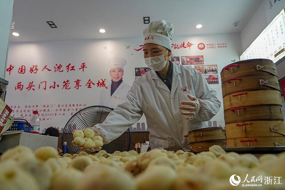 3月31日，在浙江省嵊州市甘霖鎮(zhèn)，嵊州小吃從業(yè)者沈紅平把蒸熟的小籠包晾涼，打包冷藏售賣。人民網(wǎng) 章勇濤攝