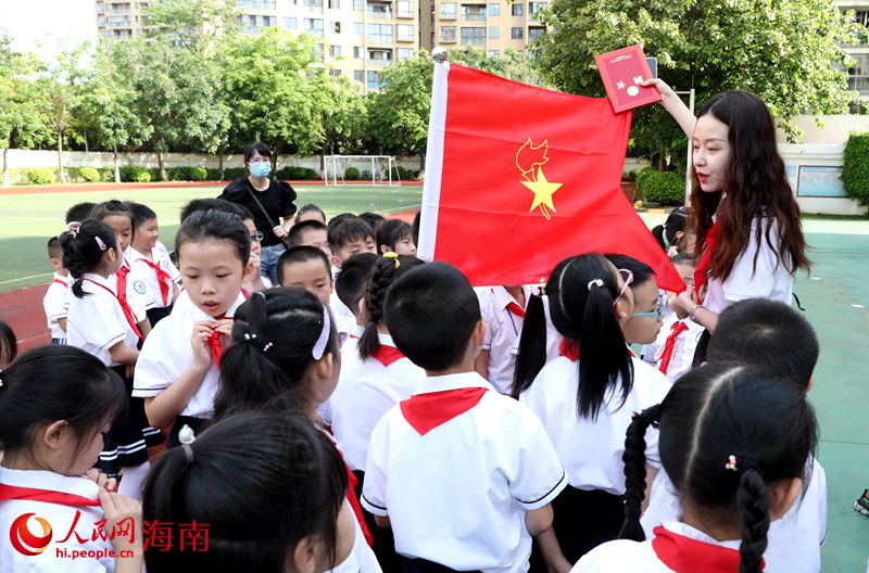 老師向少先隊員展示隊旗。人民網(wǎng) 符武平攝