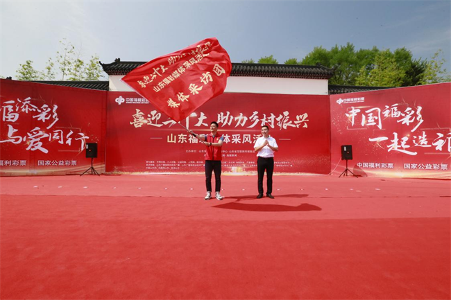 為媒體采風(fēng)團(tuán)授旗。 山東省福彩供圖