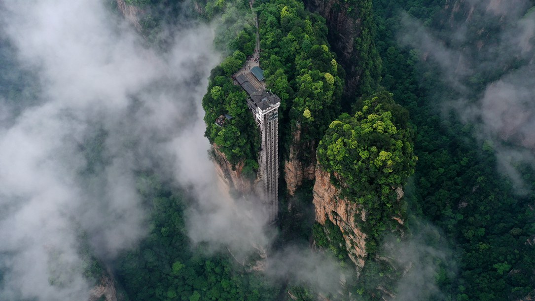 位于張家界武陵源景區(qū)的百龍?zhí)焯蓁偳对谠旗F繚繞的峰林間，雄偉壯觀。吳勇兵攝