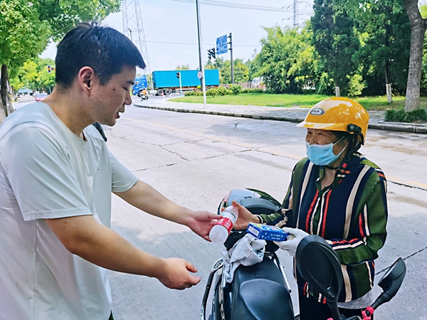何超為過路的老人送上礦泉水和冷飲。人民網(wǎng)記者 王繼亮攝