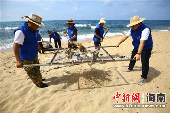 環(huán)保志愿者用篩網(wǎng)“淘”出海灘上的垃圾。