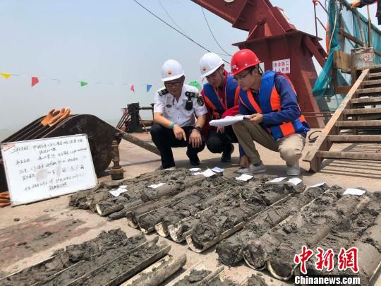 圖為勘察設(shè)計(jì)人員與海事局工作人員查看巖芯情況?！∥赫?攝