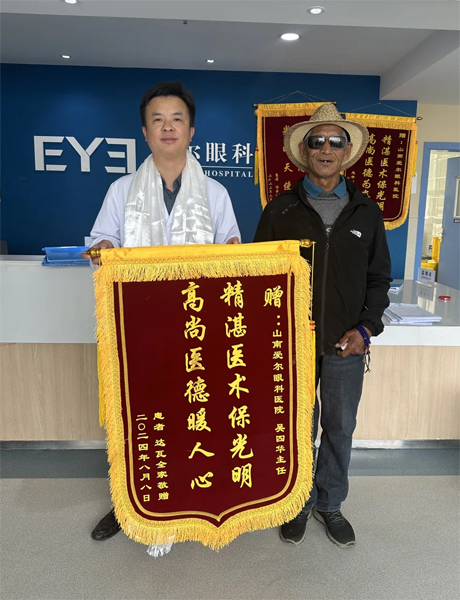 達(dá)瓦老人向吳四華（左）贈送錦旗。受訪者供圖
