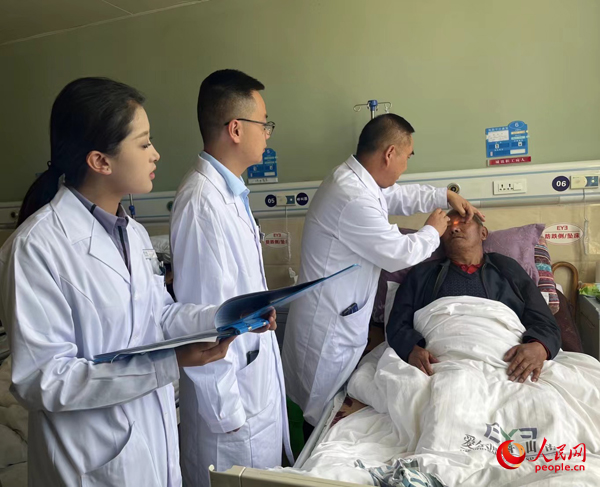 董光明（左三）帶領(lǐng)醫(yī)生對患者進(jìn)行術(shù)前檢查。人民網(wǎng)記者 杜燕飛攝