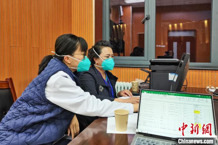 8月9日，楊蘇喬(左)在拉薩方艙醫(yī)院指揮部讀取艙內(nèi)患者胸部CT?！∈茉L者供圖