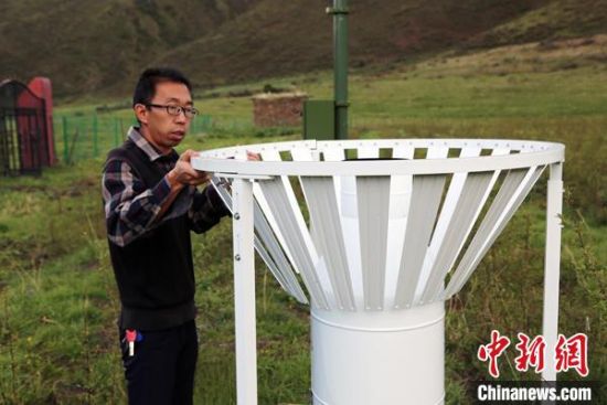 圖為班瑪縣氣象局工作人員在維護藏雪茶基地氣候站。青海省氣象局供圖