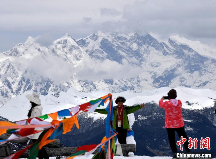 圖為5月14日，西藏林芝色季拉山觀景臺，游客與南迦巴瓦峰合影。　李林 攝