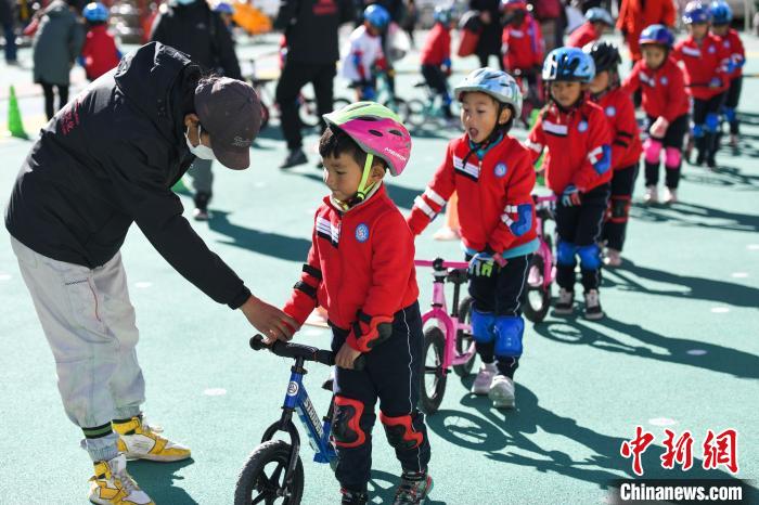 圖為拉薩市實(shí)驗(yàn)幼兒園孩子們在教練的指導(dǎo)下練習(xí)滑步車?！『闻罾?攝