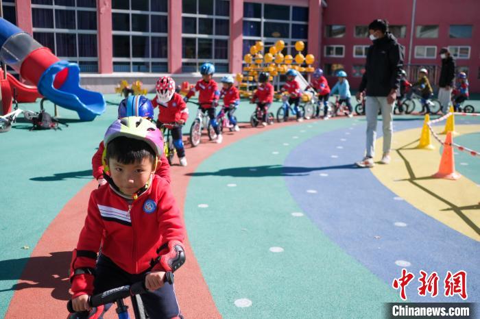 圖為拉薩市實(shí)驗(yàn)幼兒園孩子們在教練的指導(dǎo)下練習(xí)滑步車?！『闻罾?攝