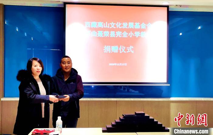 圖為西藏高山文化發(fā)展基金會理事長溫麗向聶榮縣完全小學負責人捐助儀器。　于賓 攝