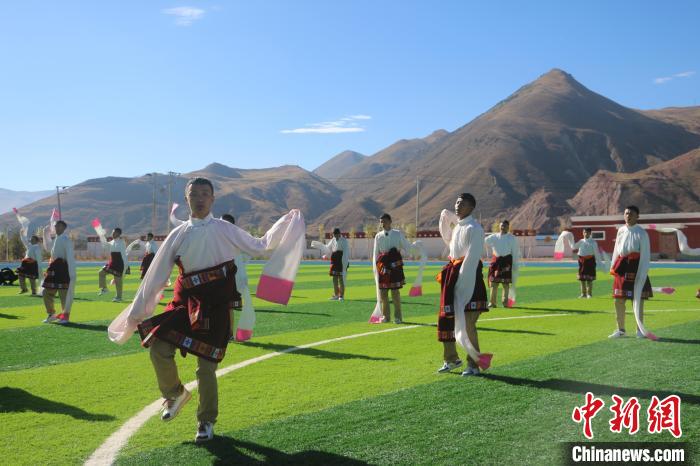 圖為青海師范大學(xué)附屬玉樹實驗學(xué)校學(xué)生在綠茵場跳起囊謙古舞—卓根瑪?！〕逃?攝