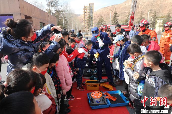 圖為小朋友們聽消防員講解消防器材。　楊龍建 攝