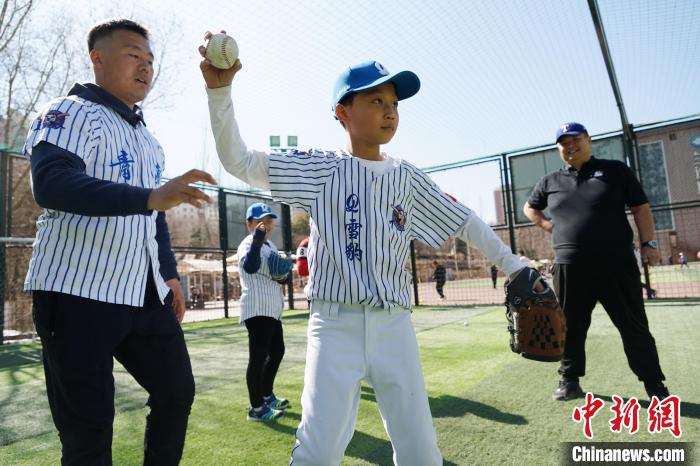 圖為教練指導(dǎo)小棒球手?jǐn)S球技術(shù)?！●R銘言 攝