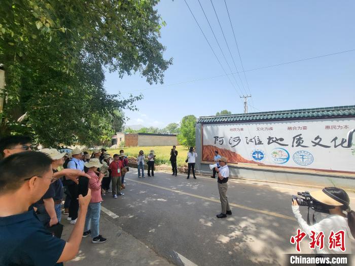圖為中國地質(zhì)大學(xué)(北京)教授張緒教介紹村落情況。　胡友軍 攝