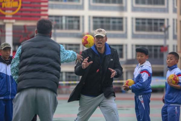 在高原上教孩子們打手球，“慢慢兒來(lái)，甭著急！”