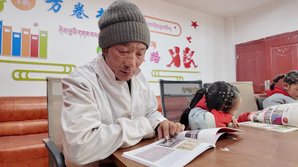 一位當(dāng)?shù)卮迕窈秃⒆觽冊谀良視堇锉M情享受閱讀時光。申扎縣融媒體中心供圖