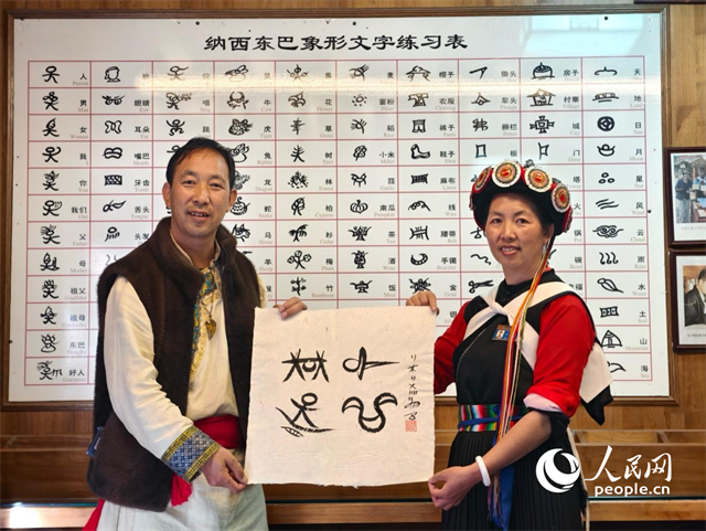 人民網(wǎng)“行進中國”云南調(diào)研采訪團走進麗江，和閏元現(xiàn)場用東巴文寫下“行進中國”。人民網(wǎng)記者 符皓攝